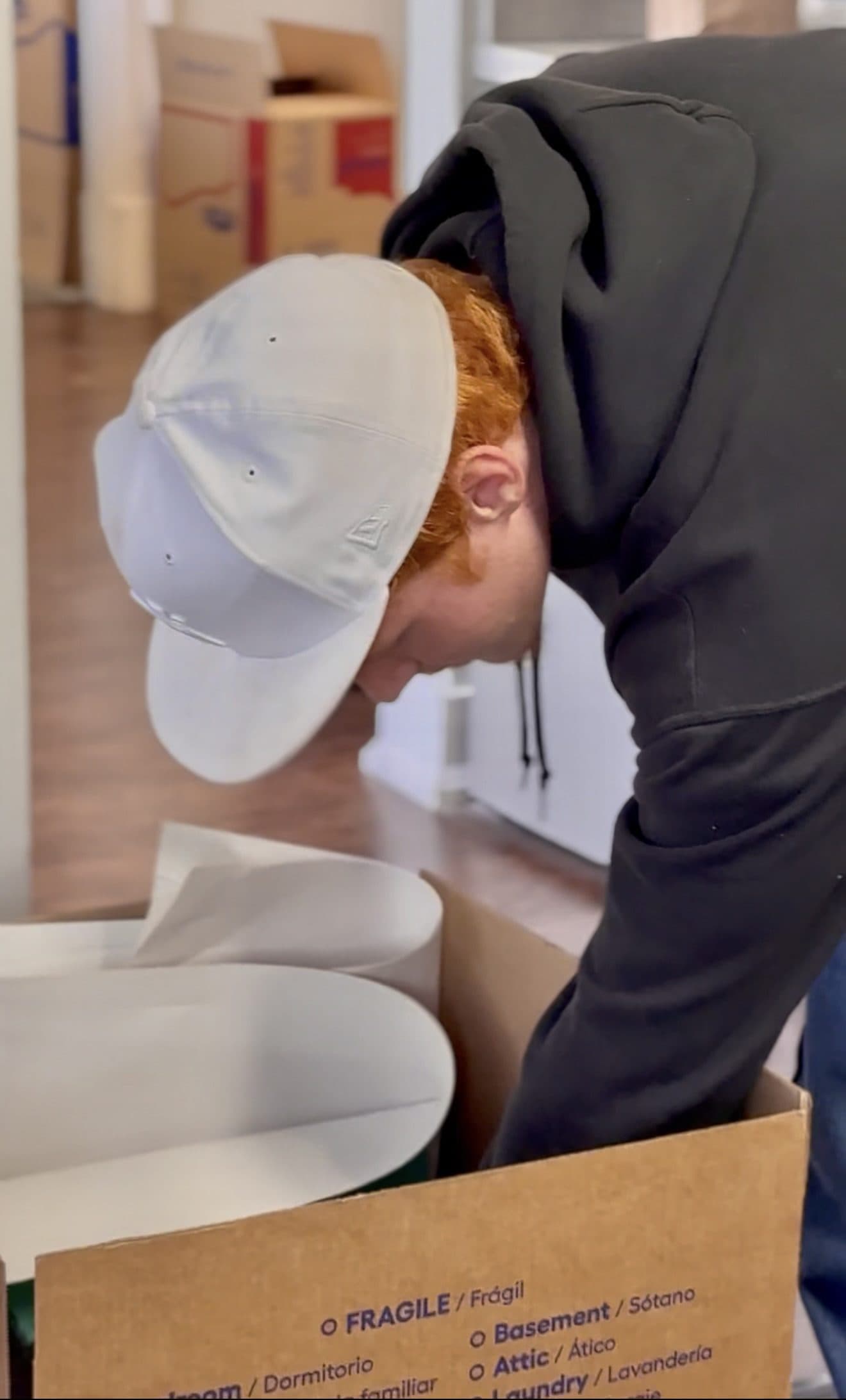 A Jam'N Moving crew member packing dishes into a labelled fragile carton
