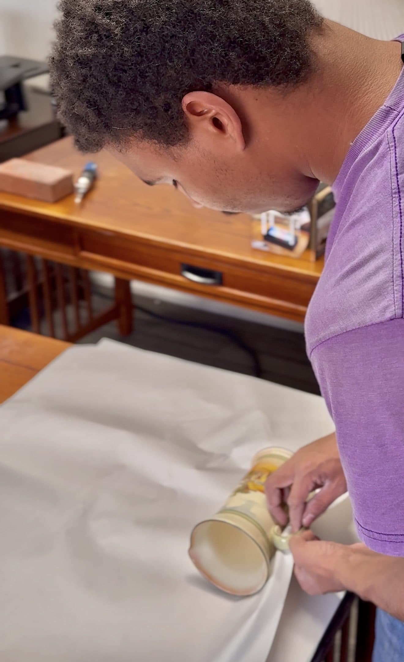 A Jam'N Moving crew member carefully wrapping a keepsake in packing paper