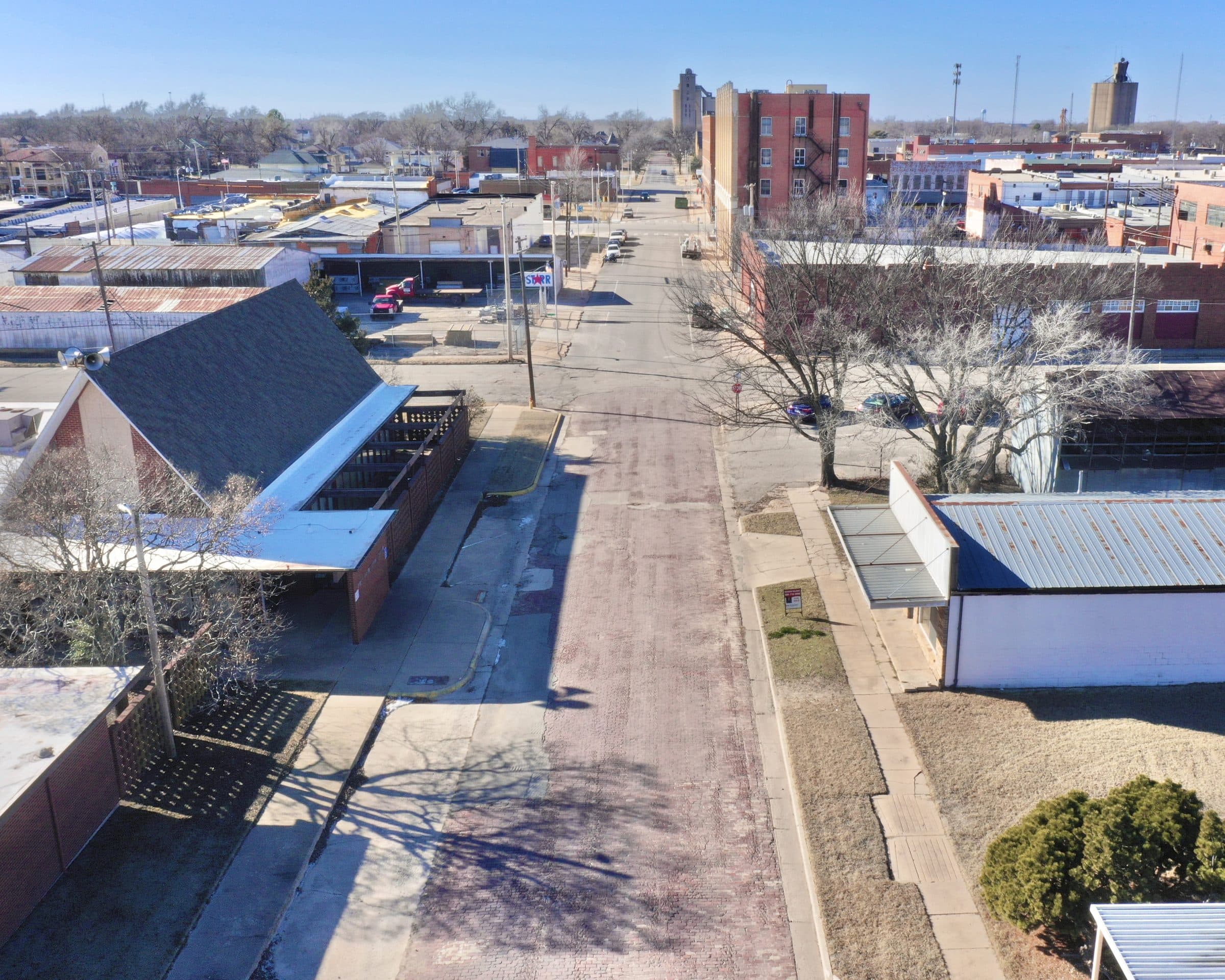 Aerial view down a brick street through downtown Blackwell, Oklahoma, with the grain elevator on the skyline